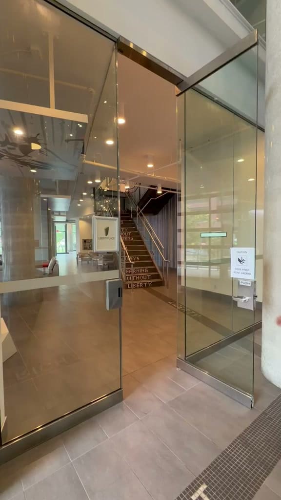 Frameless glass doors being hung across a building lobby